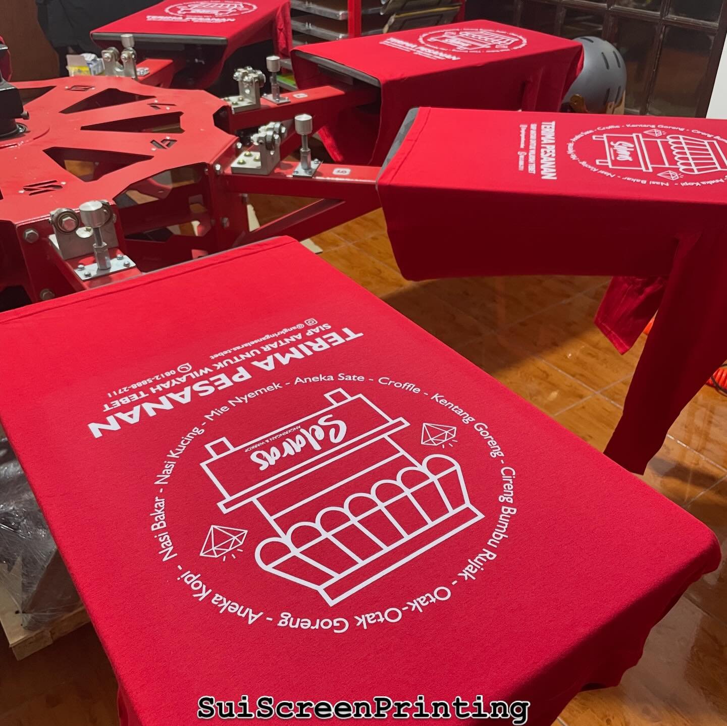 Mesin sablon carousel dengan kaos merah